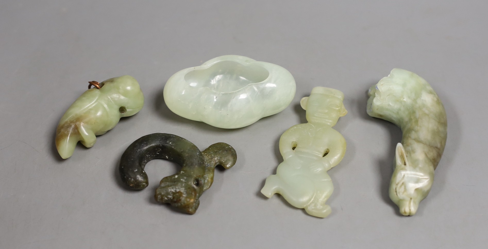 Four Chinese jade or hardstone carvings and a brushwasher, largest 9.2cm